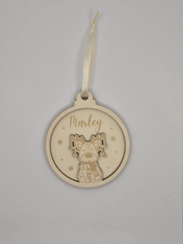 Detail gegraveerde houten kerstbal met rendier Close-up van gepersonaliseerde houten kerstbal met gravure rendier en eigen tekst