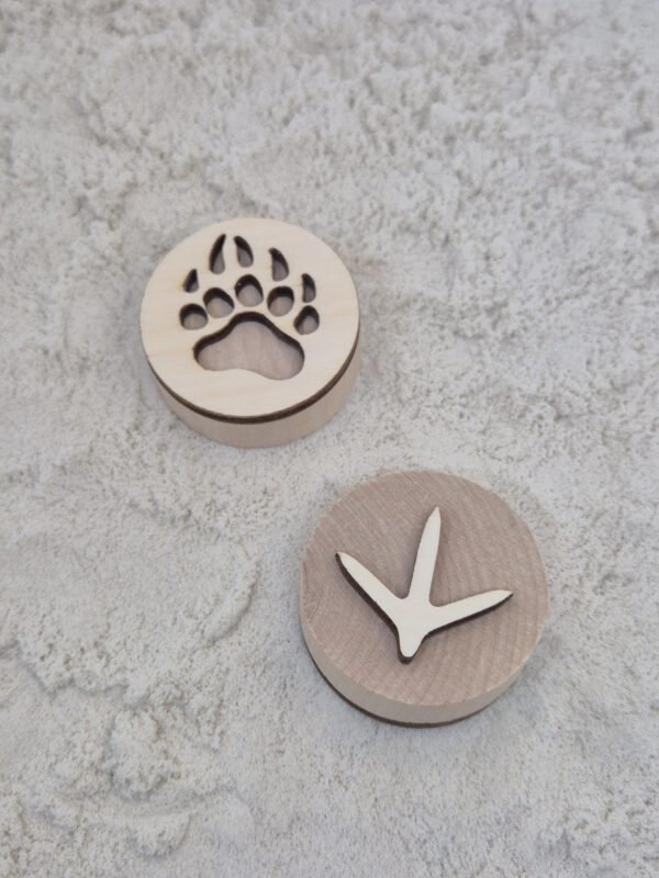 Kind speelt met houten stempels in kinetisch zand – sensorisch speelgoed peuter Peuter gebruikt houten stempels in kinetisch zand tijdens sensorisch spel en ontwikkelt fijne motoriek