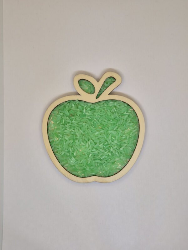 Sensorische vulvorm appel– groene speelrijst Houten sensorische vulvorm in de vorm van een appel gevuld met groene speelrijst, geschikt voor sensorisch spel en fijne motoriek.