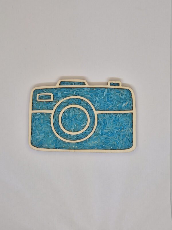 Houten sensorische vulvorm in de vorm van een camera gevuld met blauwe speelrijst, geschikt voor sensorisch spel en fijne motoriek.