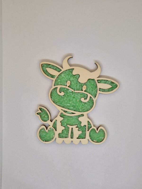 Houten sensorische vulvorm in de vorm van een koe gevuld met groene speelrijst, geschikt voor sensorisch spel en fijne motoriek.