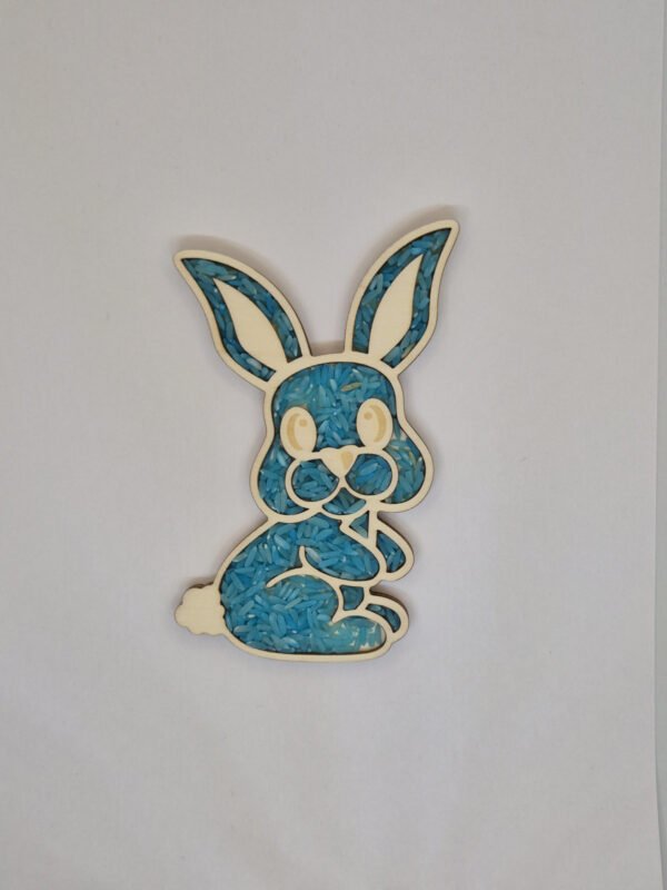 Houten sensorische vulvorm in de vorm van een konijn gevuld met blauwe speelrijst, geschikt voor sensorisch spel en fijne motoriek.