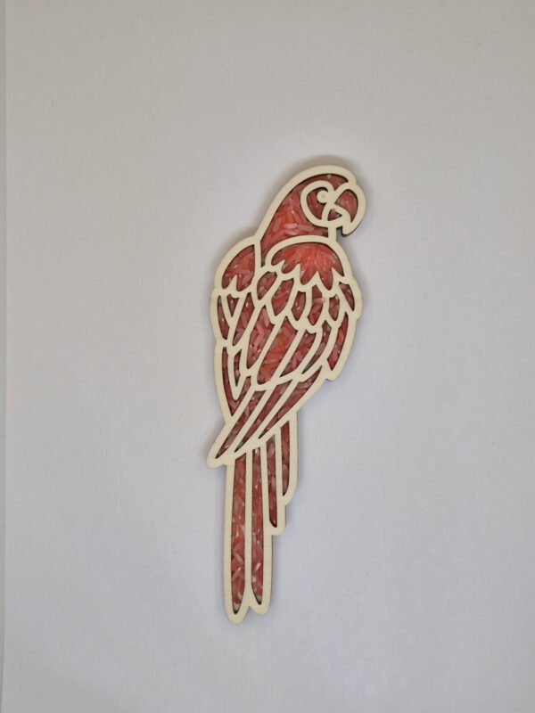 Houten sensorische vulvorm in de vorm van een papagaai gevuld met rode speelrijst, geschikt voor sensorisch spel en fijne motoriek.