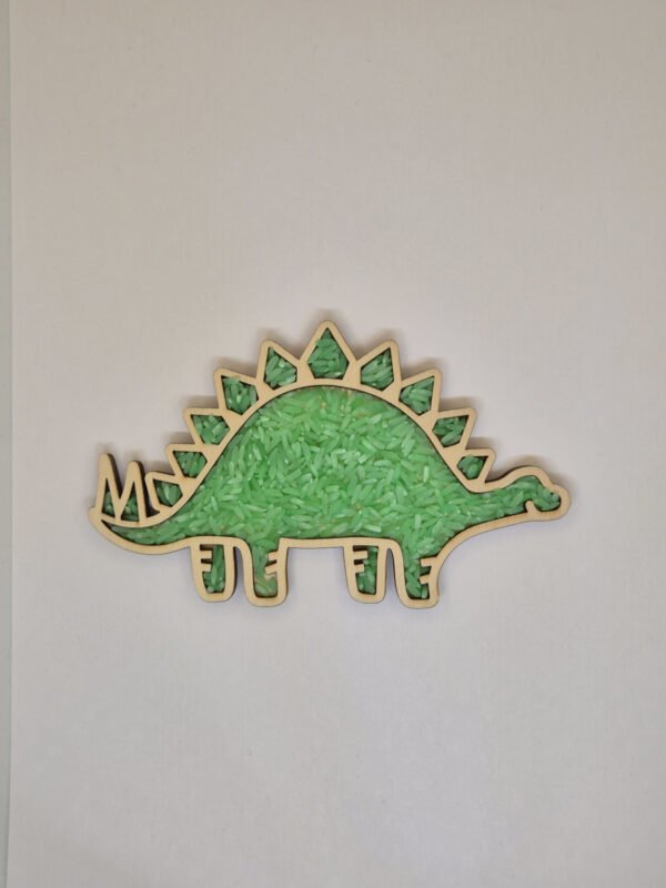 Houten sensorische vulvorm in de vorm van een stegosurus gevuld met groene speelrijst, geschikt voor sensorisch spel en fijne motoriek.