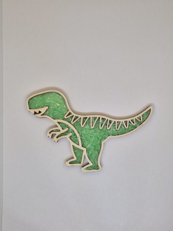 Houten sensorische vulvorm in de vorm van een t-rex gevuld met groene speelrijst, geschikt voor sensorisch spel en fijne motoriek.