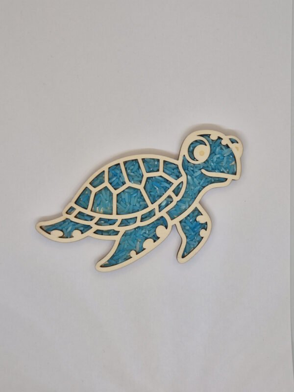 Houten sensorische vulvorm in de vorm van een zeeschildpad gevuld met blauwe speelrijst, geschikt voor sensorisch spel en fijne motoriek.