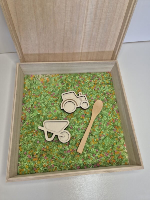 Sensorische speelbak met speelrijst – houten bak met lepel, tractor en kruiwagen Houten sensorische speelbak gevuld met speelrijst lentemix met houten lepel, tractor en kruiwagen speelgoed voor kinderen