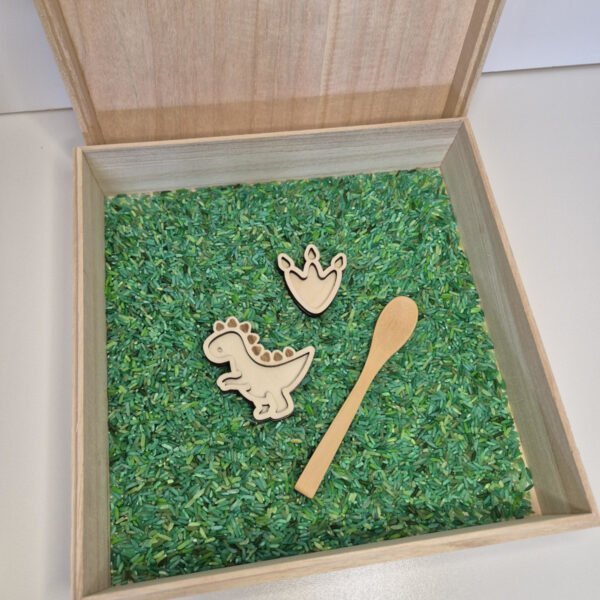 Houten sensorische speelbak gevuld met speelrijst bosmix met houten lepel, dino en dinopootafdruk speelgoed voor kinderen