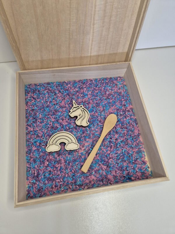 Sensorische speelbak met speelrijst – houten bak met lepel, unicorn en regenboog Houten sensorische speelbak gevuld met speelrijst unicornmix met houten lepel, unicorn en regenboog speelgoed voor kinderen