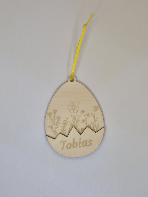 Houten paashanger paasei met naam in paastak – persoonlijke paasdecoratie Gepersonaliseerde houten paashanger paasei met naam hangend in een paastak als paasdecoratie in huis