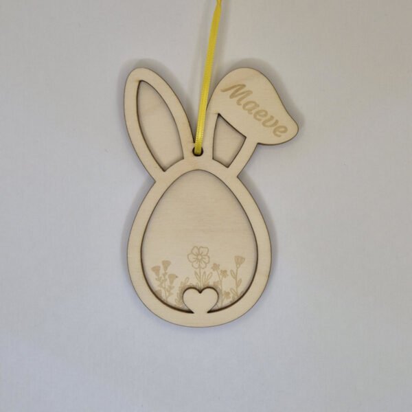 Gepersonaliseerde houten paashanger paashaas met naam hangend in een paastak als paasdecoratie in huis