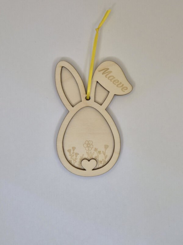 Gepersonaliseerde houten paashanger paashaas met naam hangend in een paastak als paasdecoratie in huis