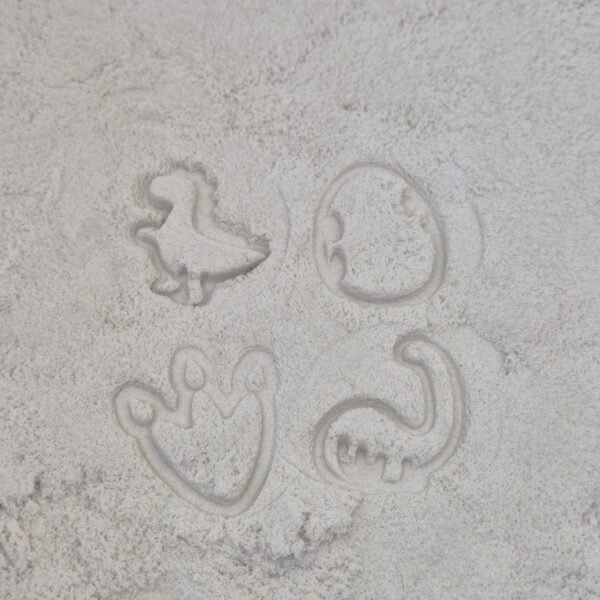 Detail van stempelafdrukken in kinetisch zand gemaakt met houten sensorische stempelset dino voor kinderen