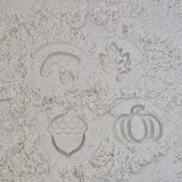 Detail van stempelafdrukken in kinetisch zand gemaakt met houten sensorische stempelset herfst voor kinderen