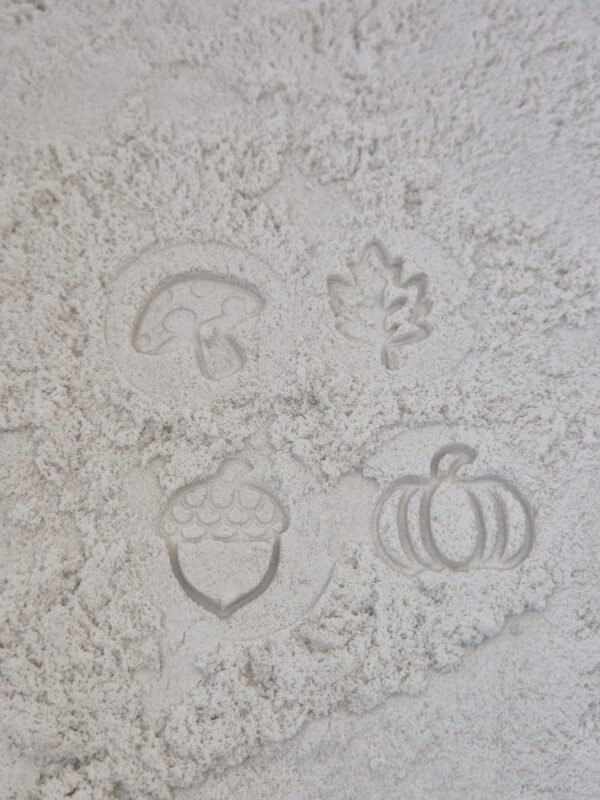 stempelset herfst op zand Detail van stempelafdrukken in kinetisch zand gemaakt met houten sensorische stempelset herfst voor kinderen