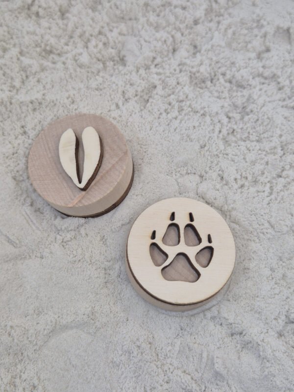 houten stempels in kinetisch zand – sensorisch speelgoed peuter Peuter gebruikt houten stempels in kinetisch zand tijdens sensorisch spel en ontwikkelt fijne motoriek